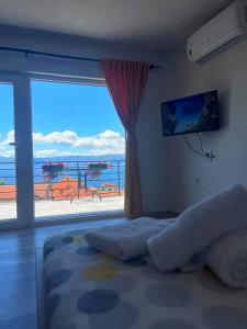 a bedroom with a large window with a view of the ocean at Apartments Sunset Jovanoski in Ohrid
