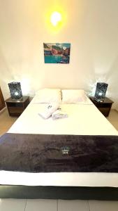 a bedroom with a bed with two nightstands and two tables at María Hosting !!! in Santa Marta