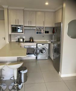 Una cocina con estufa, lavadora y secadora. en The Falls Lifestyle Estate, en Roodepoort
