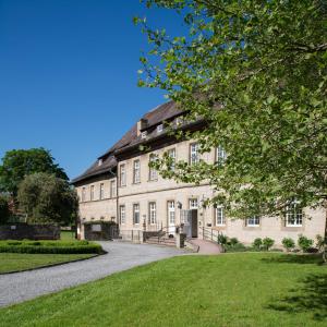 a large brick building with a pathway in front of it at Hotel Schloss Gehrden in Brakel