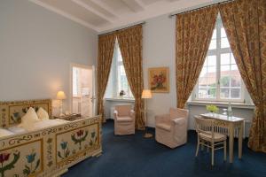 a hotel room with a bed and a table and chairs at Hotel Schloss Gehrden in Brakel