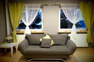 ein Wohnzimmer mit einem Sofa und 2 Fenstern in der Unterkunft Topolowa in Zgierz