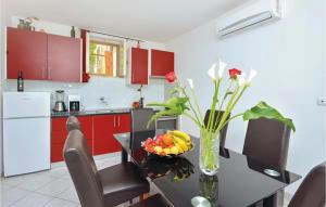 a kitchen with red cabinets and a table with a vase of flowers at Stunning Home In Split in Split