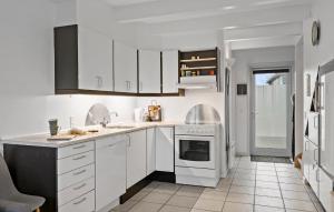 Hadsundにある3 Bedroom Gorgeous Home In Hadsundの白いキャビネットとコンロ付きオーブンを備えたキッチン