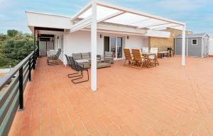 a patio with a white pergola and tables and chairs at Awesome Apartment In El Rompido in El Rompido