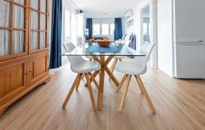 a dining room with a glass table and white chairs at Awesome Apartment In El Rompido in El Rompido
