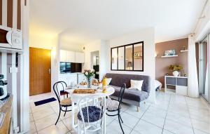 eine Küche und ein Wohnzimmer mit einem Tisch und einer Couch in der Unterkunft Pet Friendly Apartment in Saint-Georges-de-Didonne