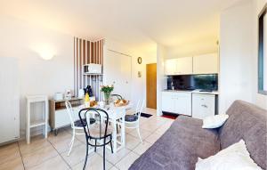 ein Wohnzimmer mit einer Couch und einem Tisch mit Stühlen in der Unterkunft Pet Friendly Apartment in Saint-Georges-de-Didonne