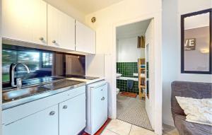eine Küche mit weißen Schränken und einem Waschbecken und ein Badezimmer in der Unterkunft Pet Friendly Apartment in Saint-Georges-de-Didonne