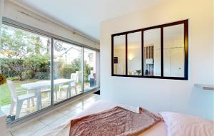 ein Schlafzimmer mit einem großen Fenster und einem Tisch mit Stühlen in der Unterkunft Pet Friendly Apartment in Saint-Georges-de-Didonne