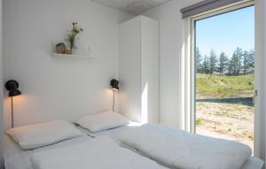 a white bedroom with a bed and a large window at Beautiful Home In Rømø With Wifi in Kongsmark +21 photos