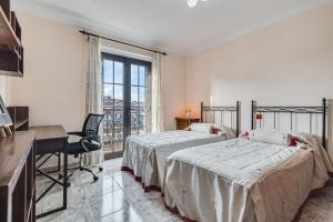 Un dormitorio con una cama y un escritorio y una ventana. en Villa Janeth Agaete, en Agaete