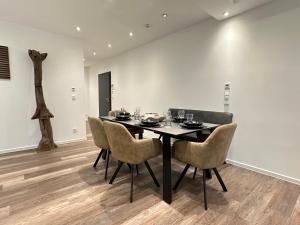 a dining room with a black table and chairs at M&K Homes Eleganter Neubau zwischen Hamburg&Ostsee mit Parkplatz in Reinfeld +7 photos
