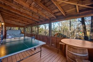 Una habitación con una mesa de ping pong en una casa. en Bearolina On My Mind, en Pigeon Forge
