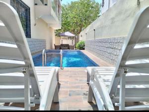 a swimming pool with two lounge chairs next to a building at Villa Maria Appartement 1 in Sali Nianiaral
