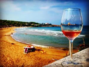 kieliszek wina siedzący na stole przy plaży w obiekcie Il Pieddo w mieście Vico del Gargano