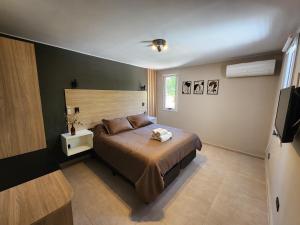 une chambre avec un grand lit et une télévision dans l'établissement Emilio Jofre IV - Céntrico, amplio y luminoso, à Villa Marini