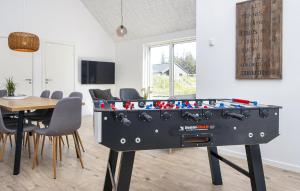 mesa de ping pong en una habitación con mesa y sillas en Cozy Home In Rømø With Wifi, en Kongsmark