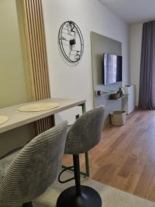 a room with a table and chairs and a clock on the wall at Sajam 2 in Novi Sad