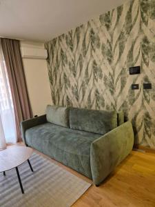a green couch in a living room with a wall at Sajam 2 in Novi Sad