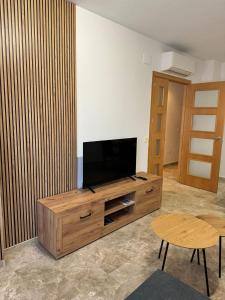 a living room with a flat screen tv on a wooden entertainment center at Apartamento Bellarhouse II in Ciudad Real