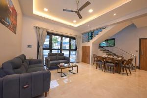 a living room with a couch and a table at Elara Villa, 3BHK Luxury Villa with Private Pool in Malavli