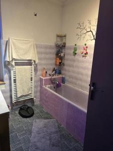a bathroom with a purple tiled tub and a sink at Chambre indépendante in Les Avenières