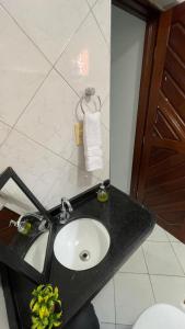 a bathroom with a black counter with a sink at Pousada Conviver in Juazeiro do Norte +43 photos