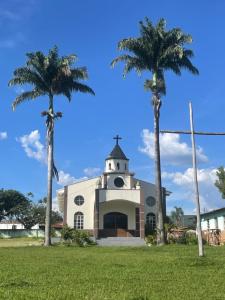 a church with two palm trees in front of it at Casa fechada in Pirenópolis