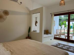 a bedroom with a bed and a large window at Charleston's Ahangama in Ahangama