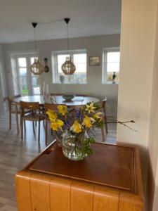 a vase of flowers on a table in a living room at Gatekeepers house in Søllested +12 photos