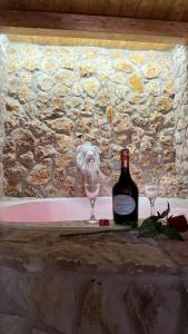a bottle of wine and two glasses on a table at Gesualdo Suites in Gesualdo