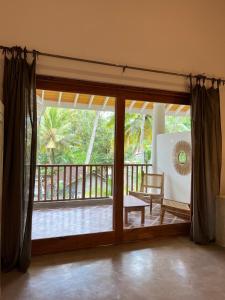 a living room with a door open to a balcony at Charleston's Ahangama in Ahangama