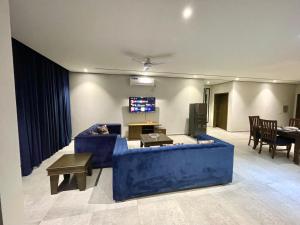 a living room with a blue couch and a tv at Sense luxury - 2 bed Apartment in Islamabad