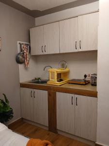 a kitchen with white cabinets and a yellow microwave at Alma Haven in Nairobi +3 photos
