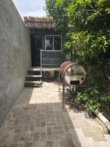 a stone walkway with a metal object next to a building at Euphorbia in Cuchilla Alta
