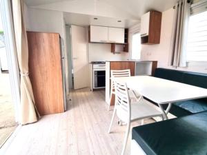 a small kitchen with a white table and chairs at Camping Sud AVEYRON dans le Rougier in Belmont-sur-Rance
