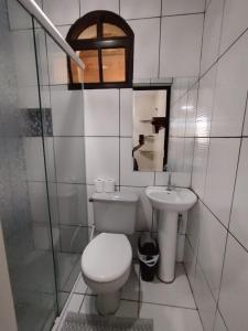 a white bathroom with a toilet and a sink at Pouso Trindade in Trindade +81 photos