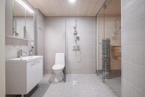 a bathroom with a shower and a toilet and a sink at Compact 2BDR Apartment with Private Sauna in Rovaniemi
