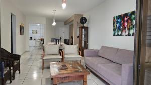 ein Wohnzimmer mit Sofa und Tisch in der Unterkunft Apto pé na areia em Meia Praia Itapema, 3 dormitórios in Itapema + 24 Fotos