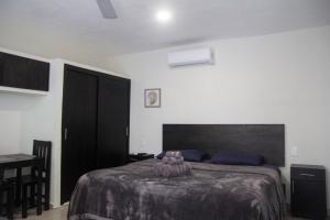 a bedroom with a bed and a table with a chair at Casa Creunza de Mar in Playa del Carmen