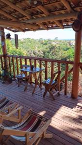 a wooden deck with a table and chairs on it at Loft Astanga Serra do Cipó in Serra do Cipo +8 photos