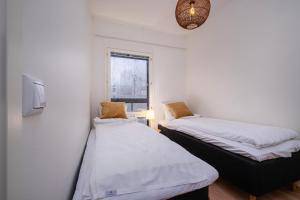 two beds in a small room with a window at Compact 2BDR Apartment with Private Sauna in Rovaniemi