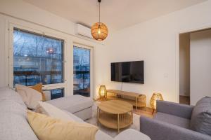 a living room with a couch and a table at Compact 2BDR Apartment with Private Sauna in Rovaniemi