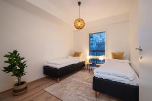 a bedroom with two beds and a potted plant at Brand New 2BDR with Private Sauna in Rovaniemi