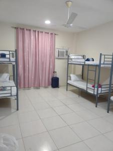 Ένα ή περισσότερα κρεβάτια σε δωμάτιο στο Muscat Galaxy Hostel