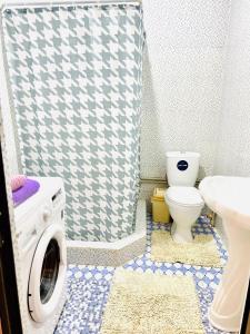 ein Badezimmer mit Waschmaschine und Toilette in der Unterkunft Turkistan 1 in Türkistan
