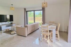 a living room with a table and a couch and a television at La Villa Sable en Provence in Saint-Saturnin-lès-Apt