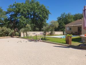 a driveway with a yard with a pool and a house at La Villa Sable en Provence in Saint-Saturnin-lès-Apt