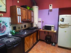 a kitchen with a stove and a refrigerator at Intiaconcagua Habitacion familiar con baño privado in Ciudad Lujan de Cuyo